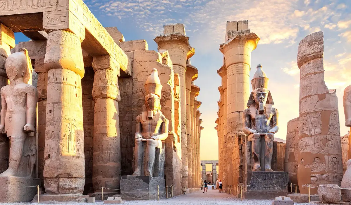 The Ramesses II colossi and columns of Luxor Temple in golden sunset light
